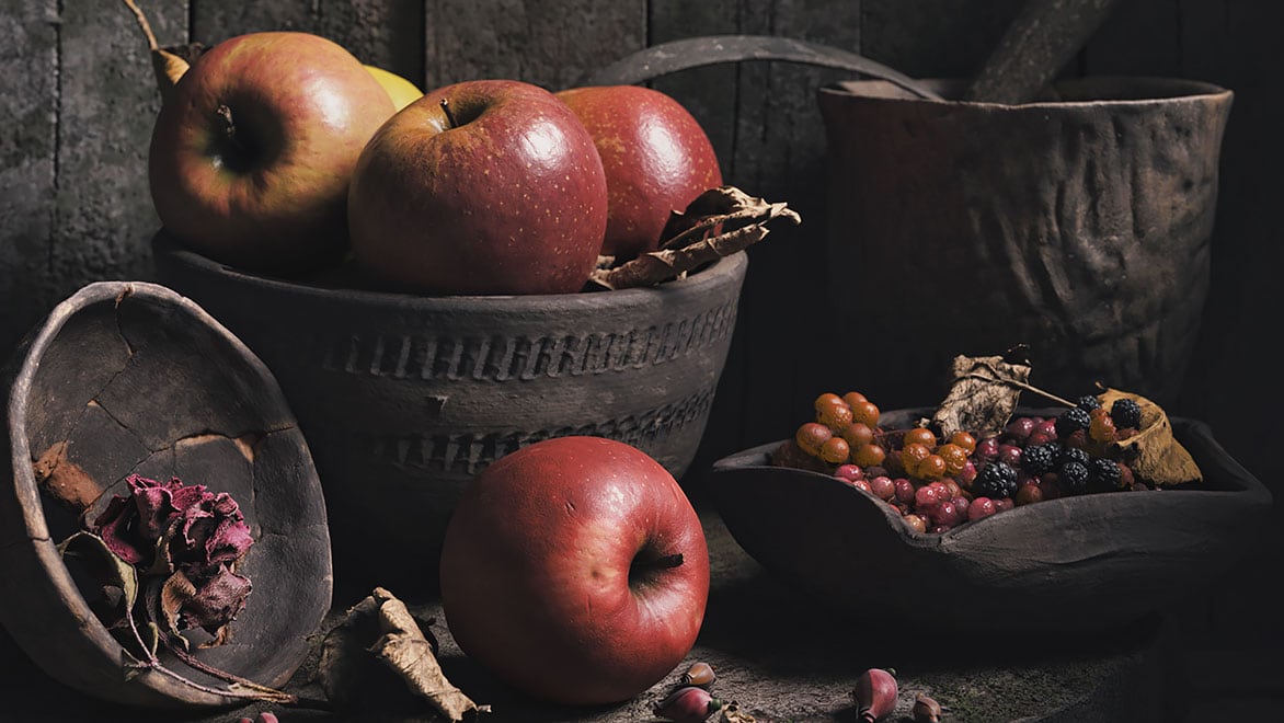 Jabłka i jagody na tle rustykalnej kuchni