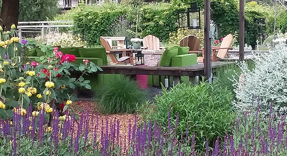 Lush flower garden and a deck with patio furniture