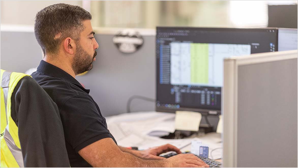 AECO professional working with asset data at a desktop computer