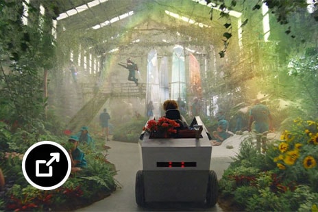 在 Fiverr 超级碗商业广告中驾驶车辆进入一个种满植物的房间的人