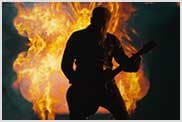 Guitarist playing in front of a flames