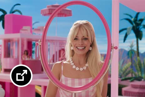 Margot Robbie 饰演的芭比娃娃正在照粉色镜子