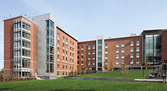 3D rendering of Framingham State University’s new residence hall, a red-brick and glass structure surrounding a quad