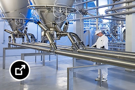 Suuria teollisia ruoan prosessointilaitteita tehtaan lattialla 
