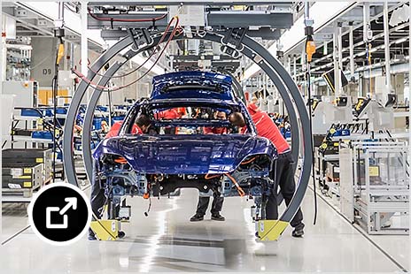A vehicle being assembled by robots in a Porsche factory