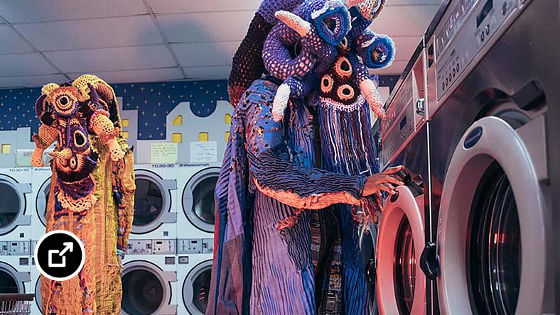 Two characters in yellow and purple costumes at a laundromat
