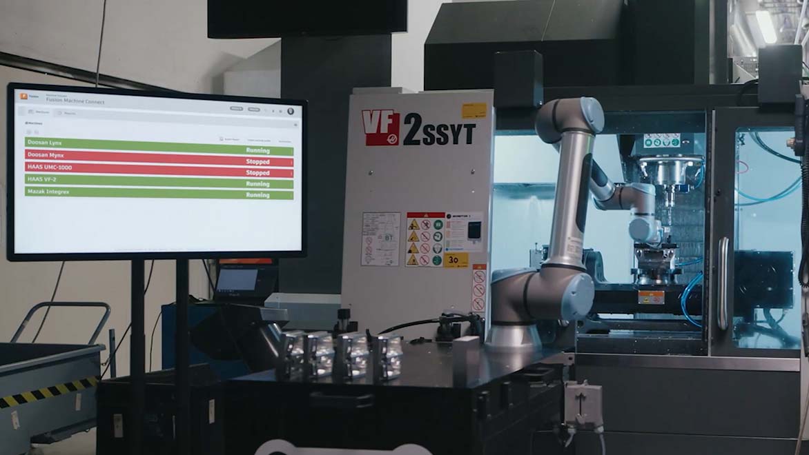 Image: A CNC machine tool is shown with a large monitor that shows the Fusion Machine Connect interface