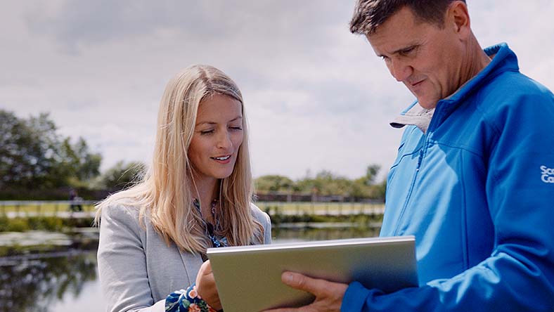 Two professionals looking over a tablet making decisions in the field