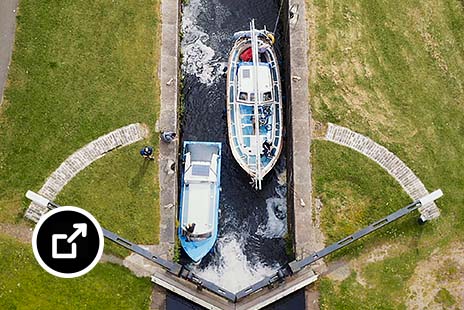 Aerial view of the two boats stopped in front of the lock gates in the Scottish Canals in Glasgow, Scotland