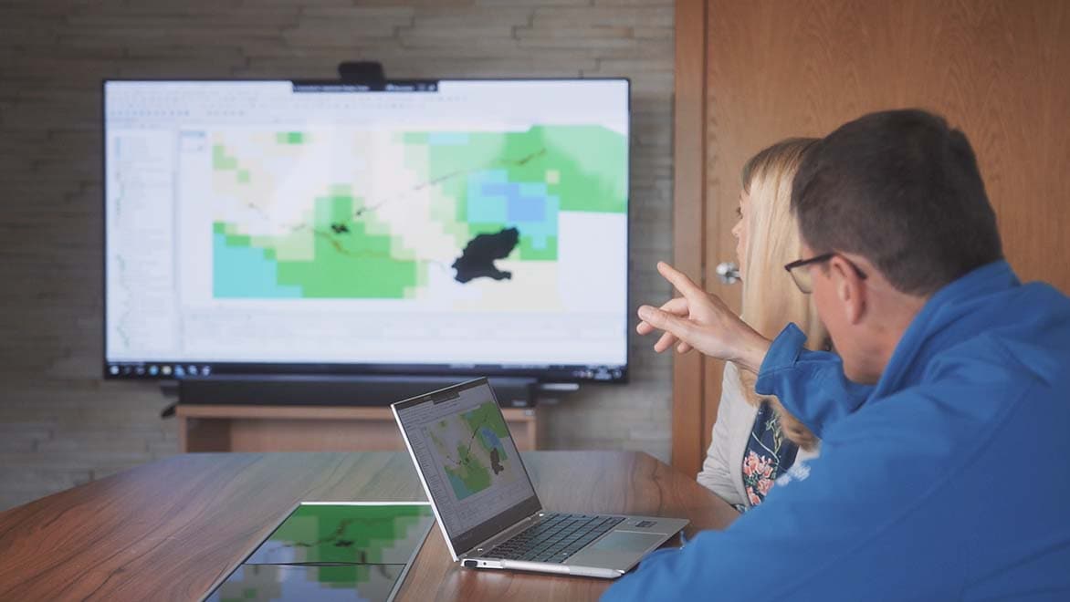 Gallery Element 2 Two professionals collaborate with ICMLive using a laptop and large monitor, indicating a productive work session.