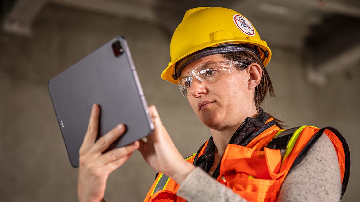 Person wearing hard hat using a tablet