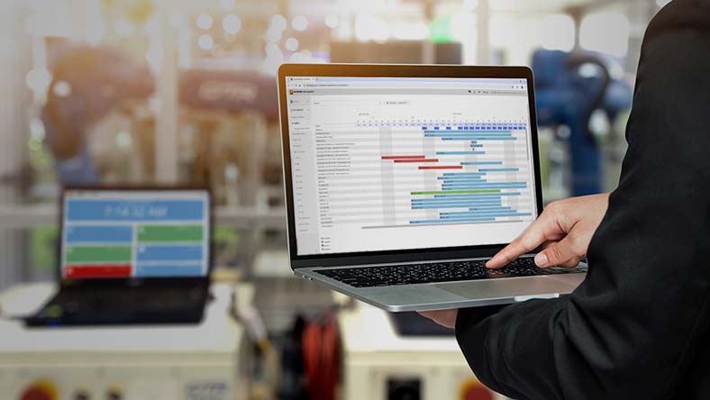 Image showing a worker using Autodesk Fusion Operations to schedule production orders.