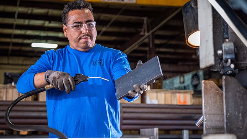 Image showing a worker in a manufacturing facility using Autodesk Fusion Operations to log product waste.