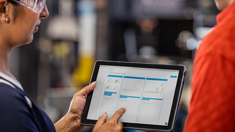 Image showing a worker with Autodesk Fusion Operations on her tablet displaying OEE and other real-time analytics of her manufacturing facility.