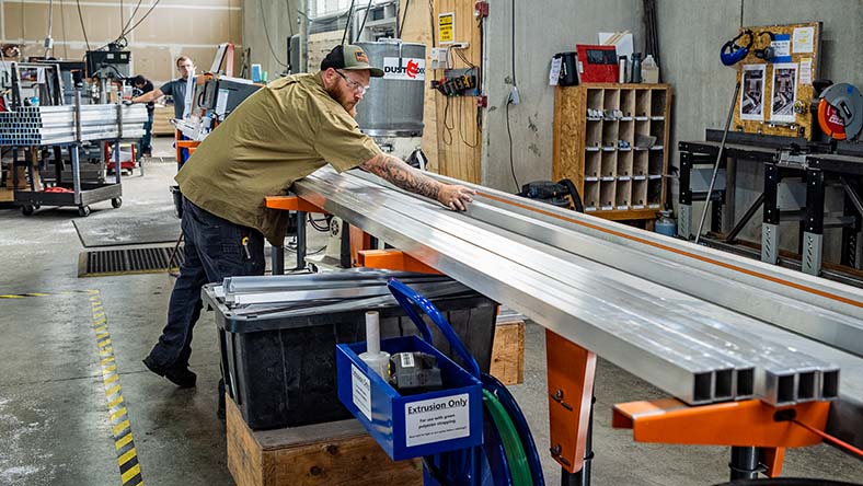 Image showing a worker using guidance from Autodesk Fusion Operations to log his production tasks.