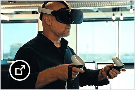 Man in VR headset holding hand controllers 