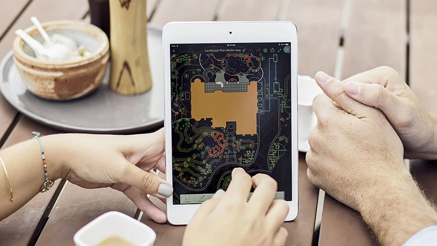 Zwei Personen betrachten auf einem Tablet ein AutoCAD-Landschaftsplanmodell