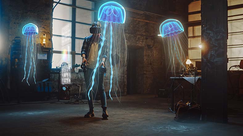Female artist wearing AR headset uses joysticks to create abstract 3D jellyfish sculpture 