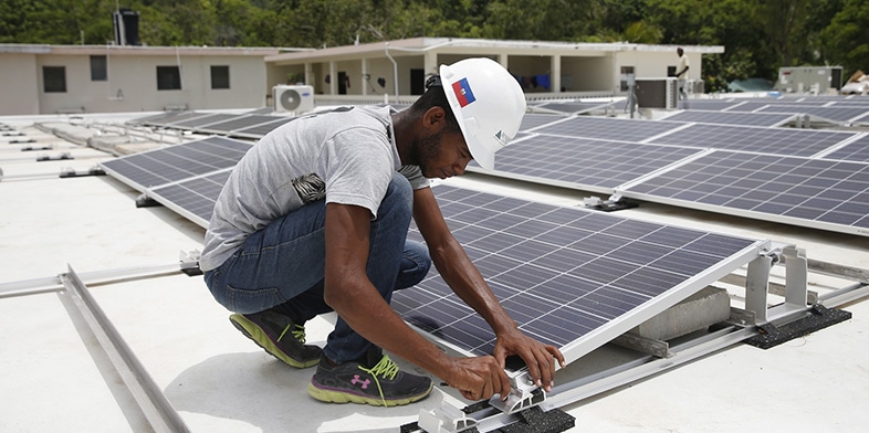 Ouvrier du bâtiment réparant un panneau solaire
