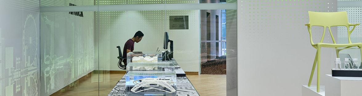 An employee working in an office, surrounded by design artefacts