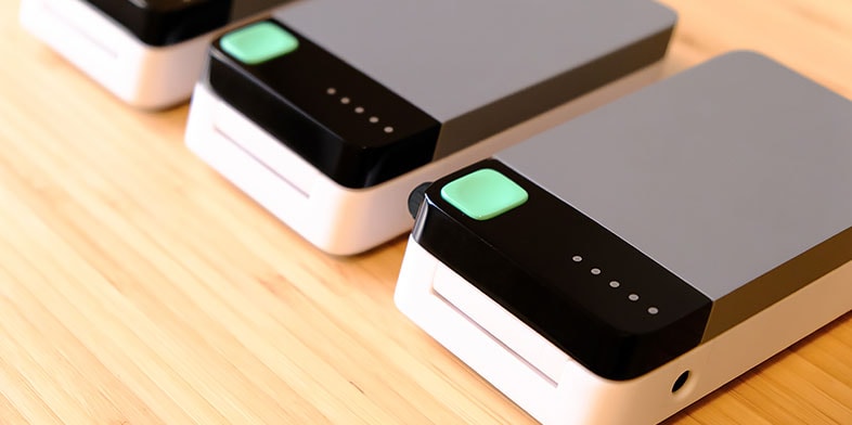Close-up of Cortex Design hardware with grayscale surfaces and green buttons