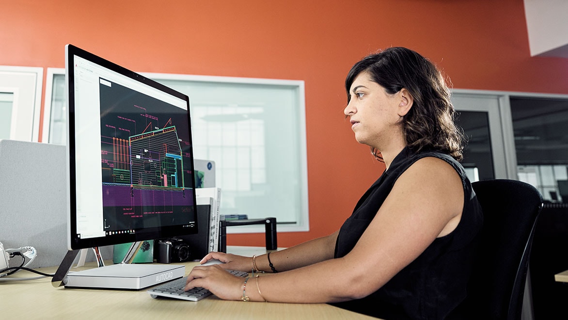 Woman using AutoCAD on a computer in an office environment