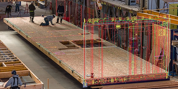 주변을 둘러싼 렌더링된 벽 다이어그램을 사용하여 합판 기초를 만들고 있는 건설 노동자 