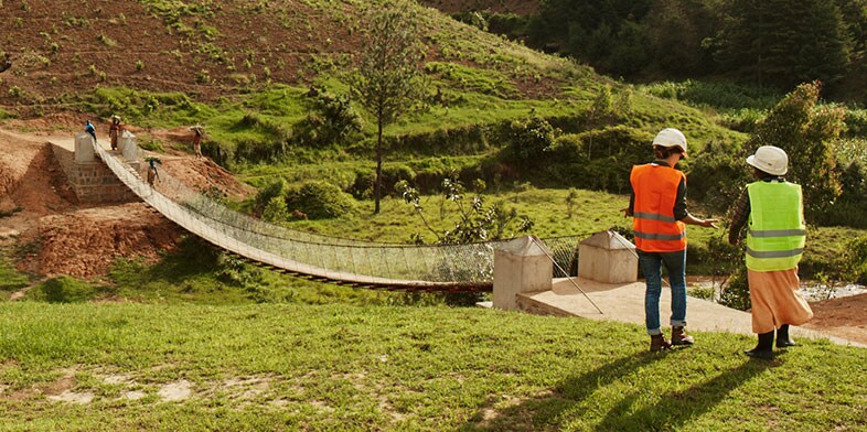 Two people consult on a bridge in Rwanda