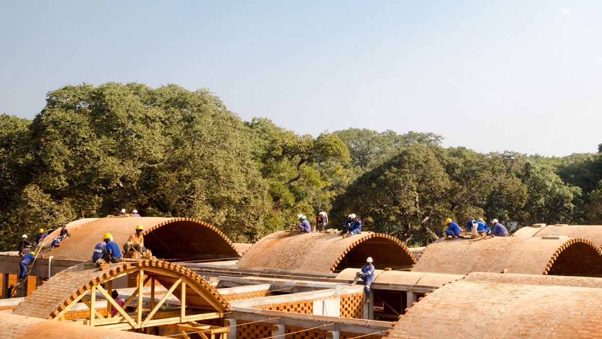Aerial view of brick roof construction with workers on rooftops