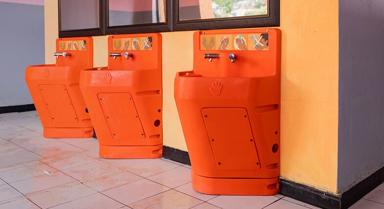 Three orange Splash handwashing stations