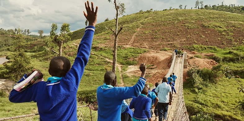 Children crossing a Bridges to Prosperity trail bridge in Rwanda