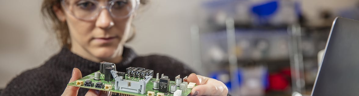 Woman holds electronic equipment at a Gradient manufacturing site
