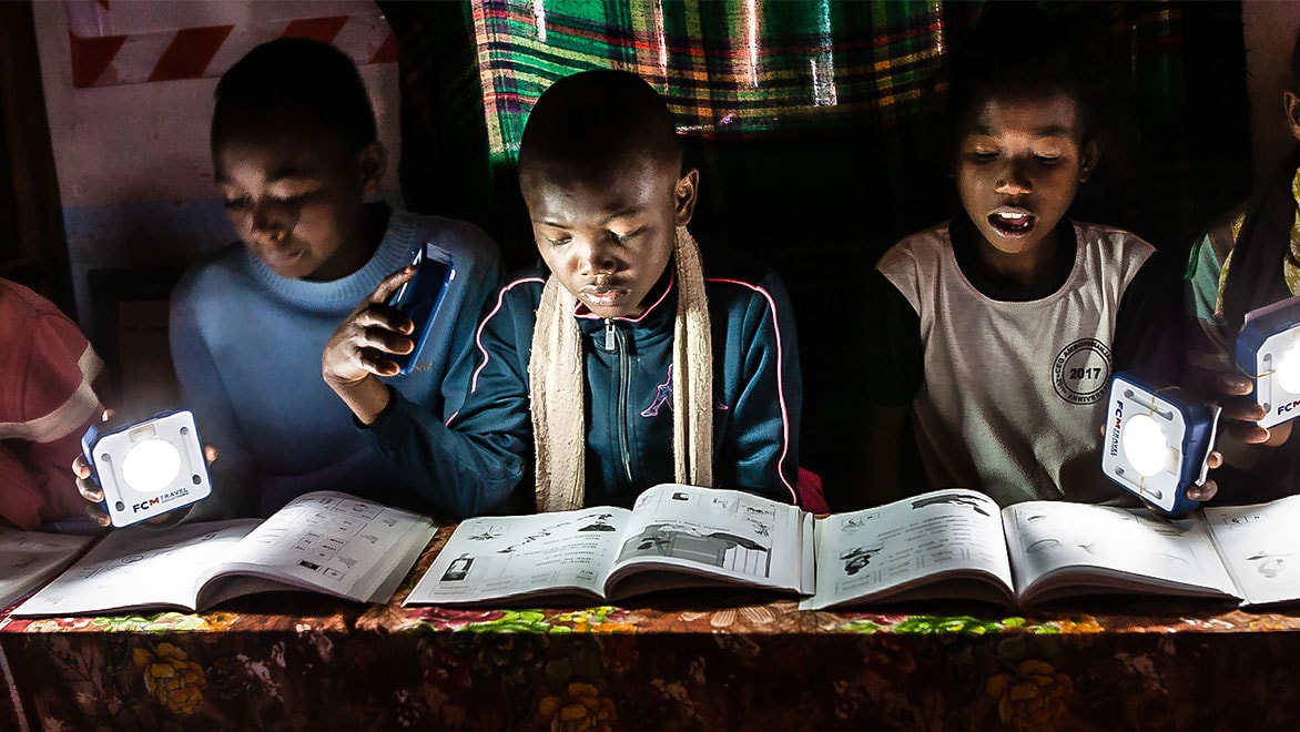 Three students reading while using SolarBuddy lights