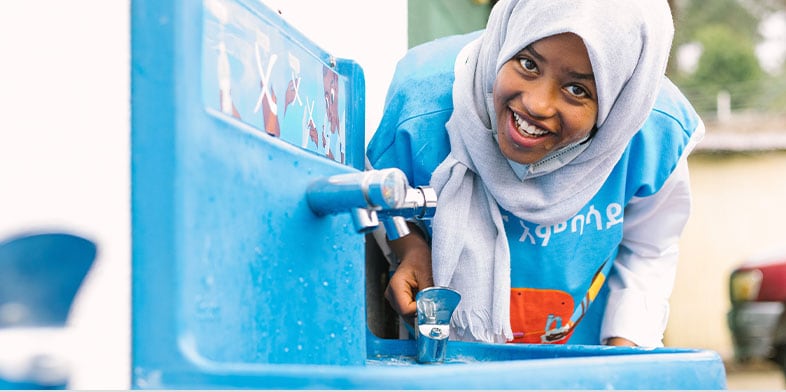 Girl uses a drinking fountain in Ethiopia